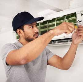 Maintenance, air conditioner technician and man with screwdriver working on ventilation for ac repair. Contractor, handyman or electric aircon machine expert problem solving, electrician with tools